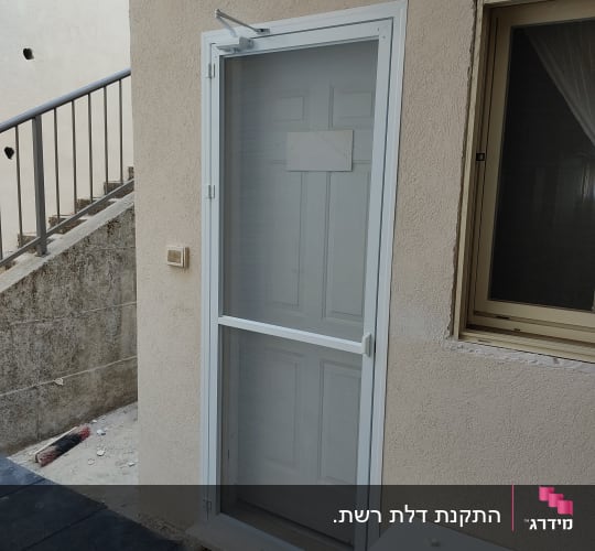 דלת אלומיניום עם מסגרת לבנה וקיר חיצוני